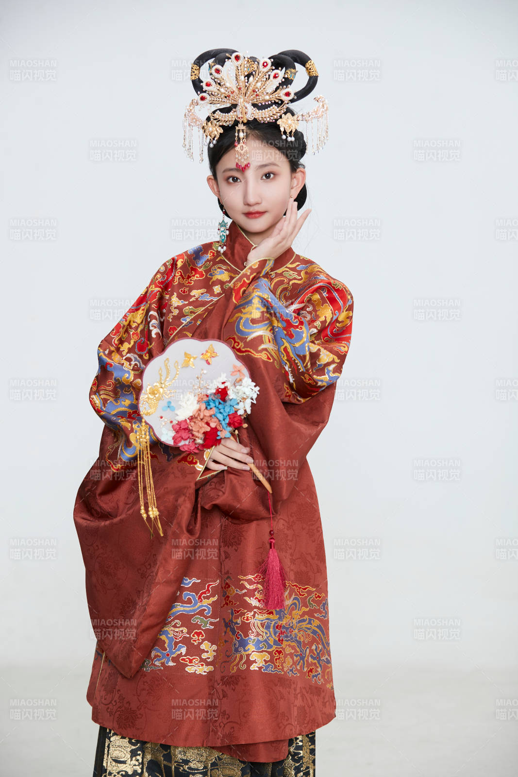白色背景下穿著明代鳳冠霞帔漢服的可愛少女