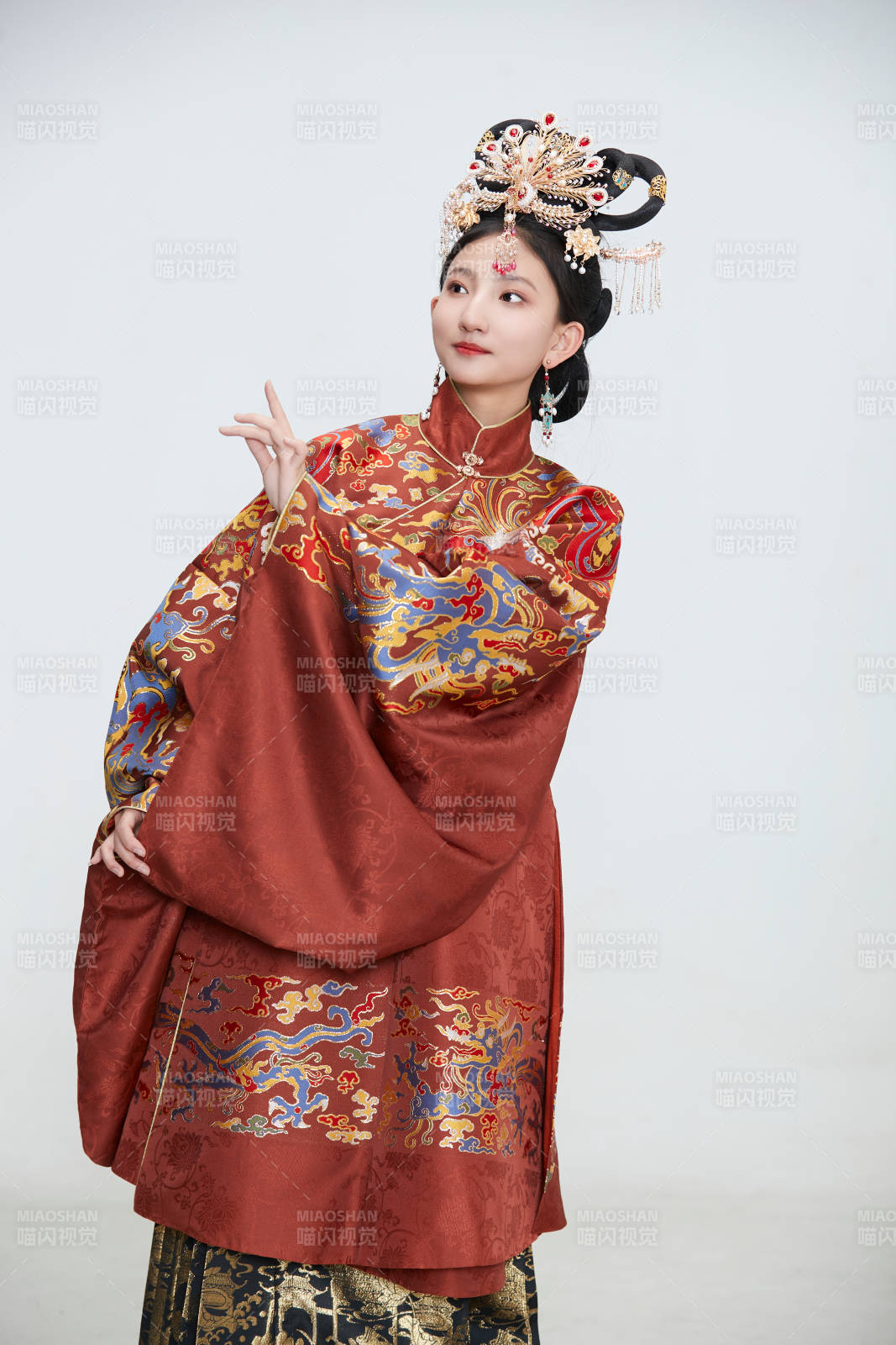 白色背景下穿著明代鳳冠霞帔漢服的可愛少女