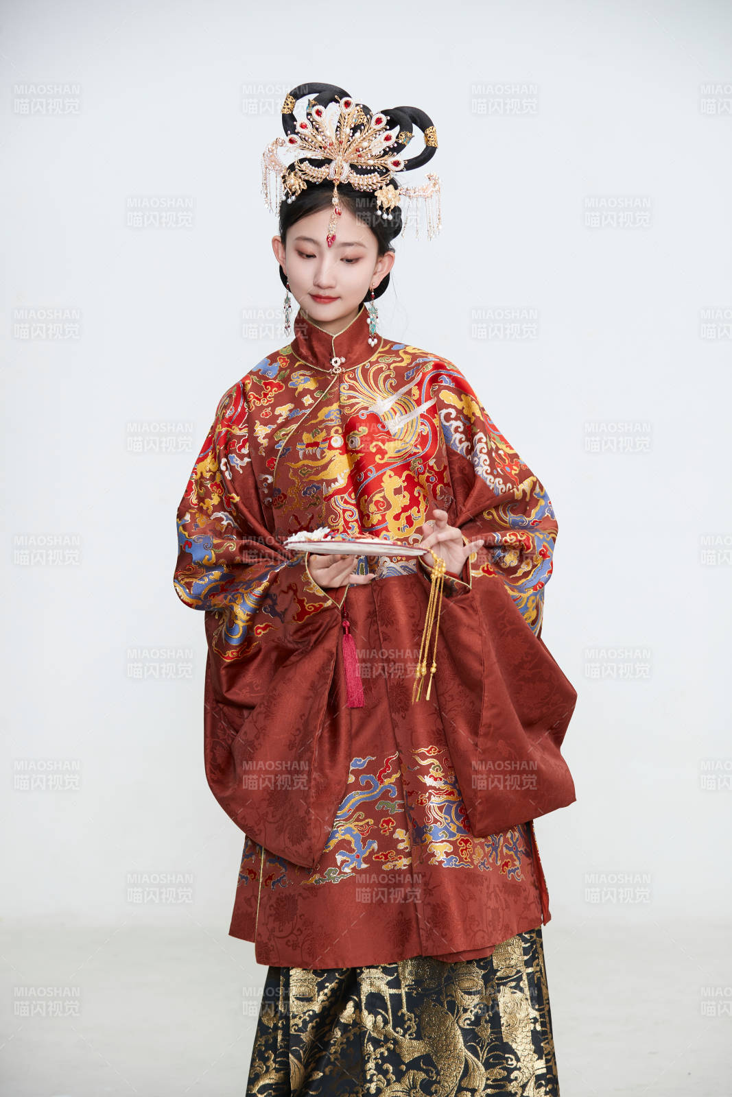 白色背景下穿著明代鳳冠霞帔漢服的可愛少女
