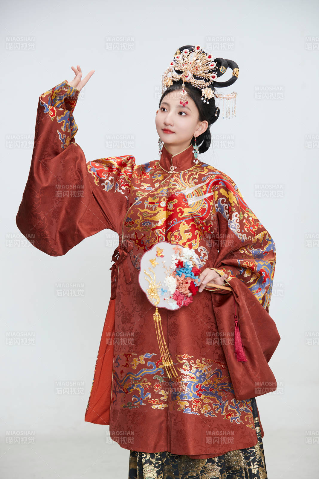白色背景下穿著明代鳳冠霞帔漢服的可愛少女