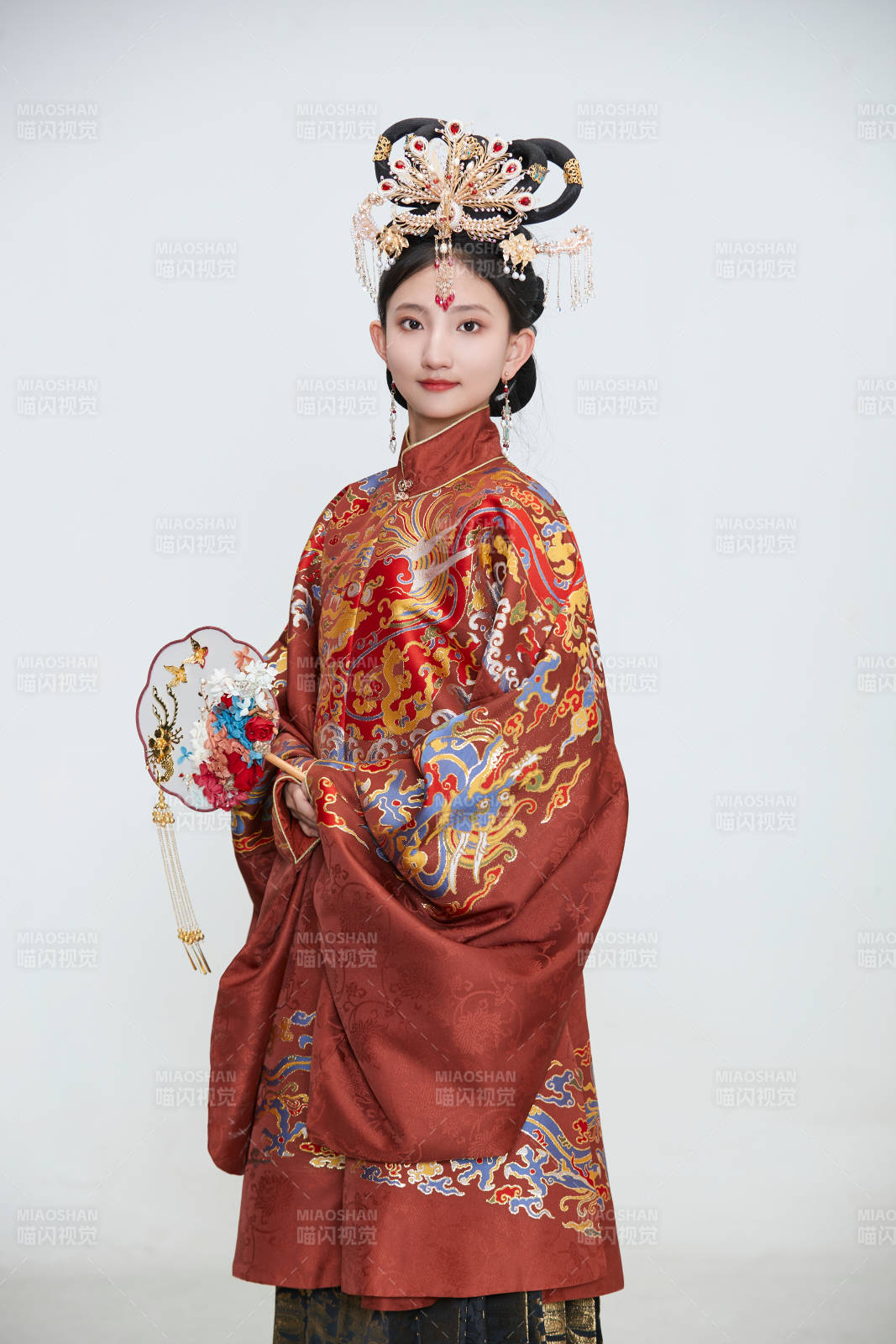 白色背景下穿著明代鳳冠霞帔漢服的可愛(ài)少女