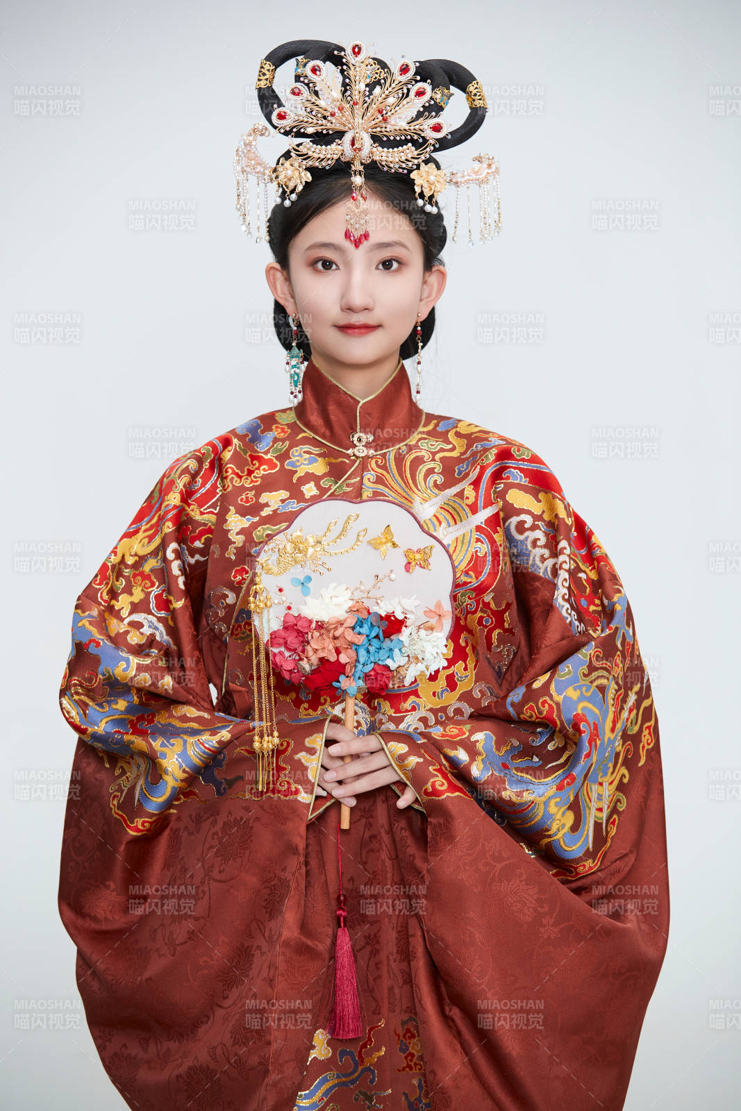 白色背景下穿著明代鳳冠霞帔漢服的可愛少女