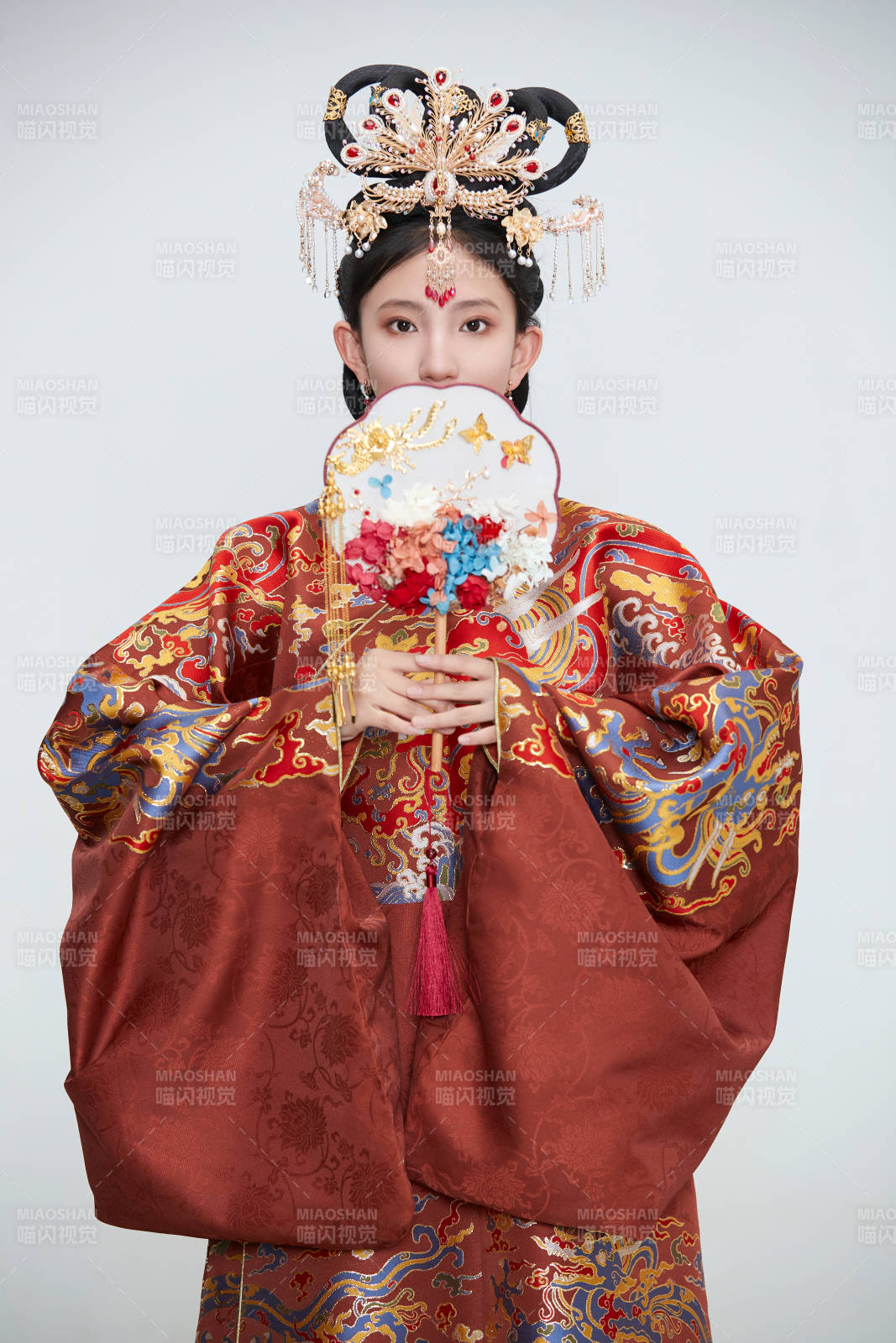 白色背景下穿著明代鳳冠霞帔漢服的可愛少女