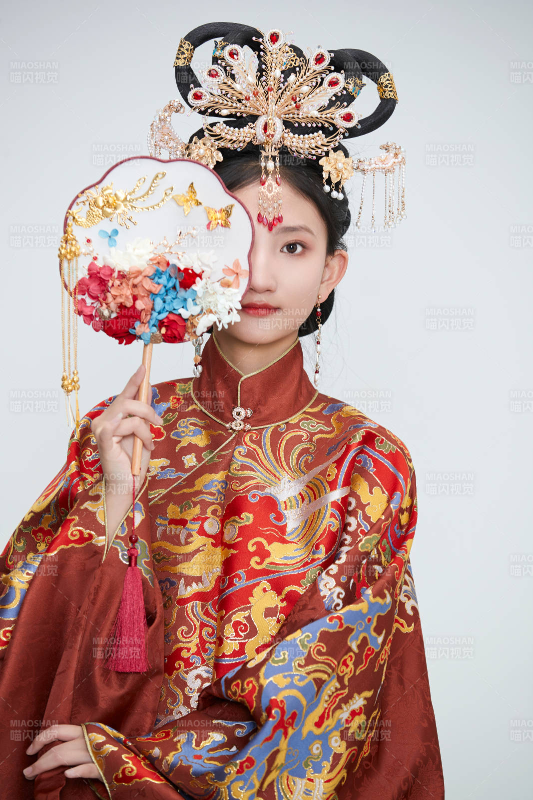 白色背景下穿著明代鳳冠霞帔漢服的可愛少女