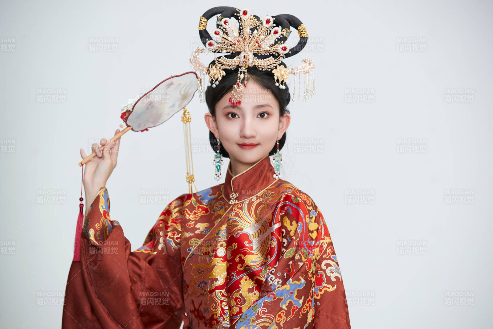 白色背景下穿著明代鳳冠霞帔漢服的可愛少女