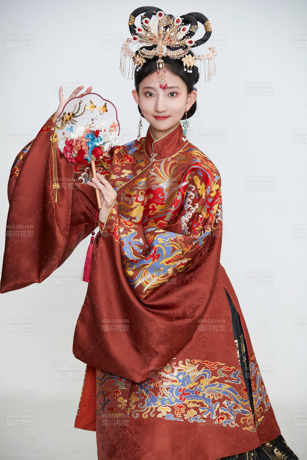 白色背景下穿著明代鳳冠霞帔漢服的可愛少女