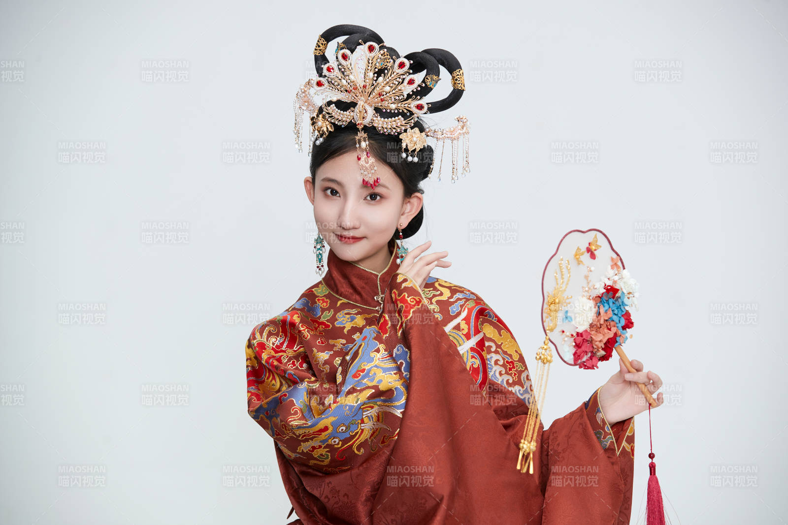 白色背景下穿著明代鳳冠霞帔漢服的可愛少女