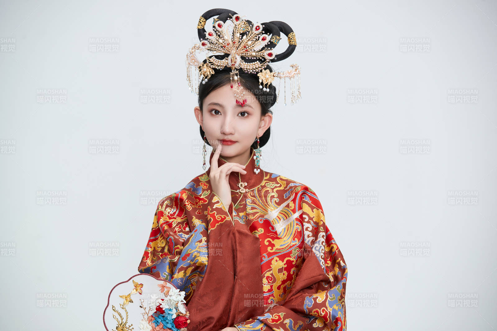 白色背景下穿著明代鳳冠霞帔漢服的可愛少女