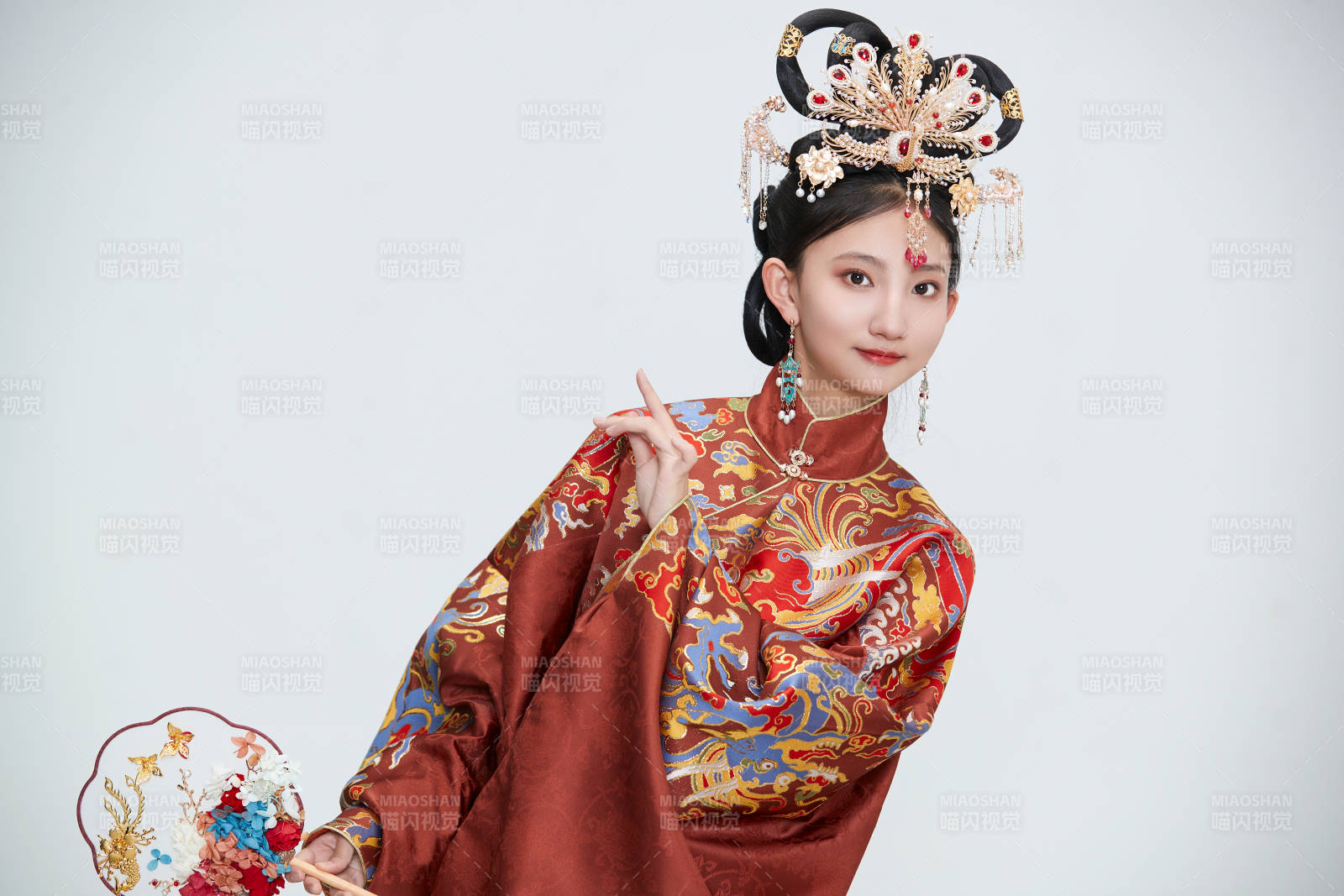 白色背景下穿著明代鳳冠霞帔漢服的可愛少女