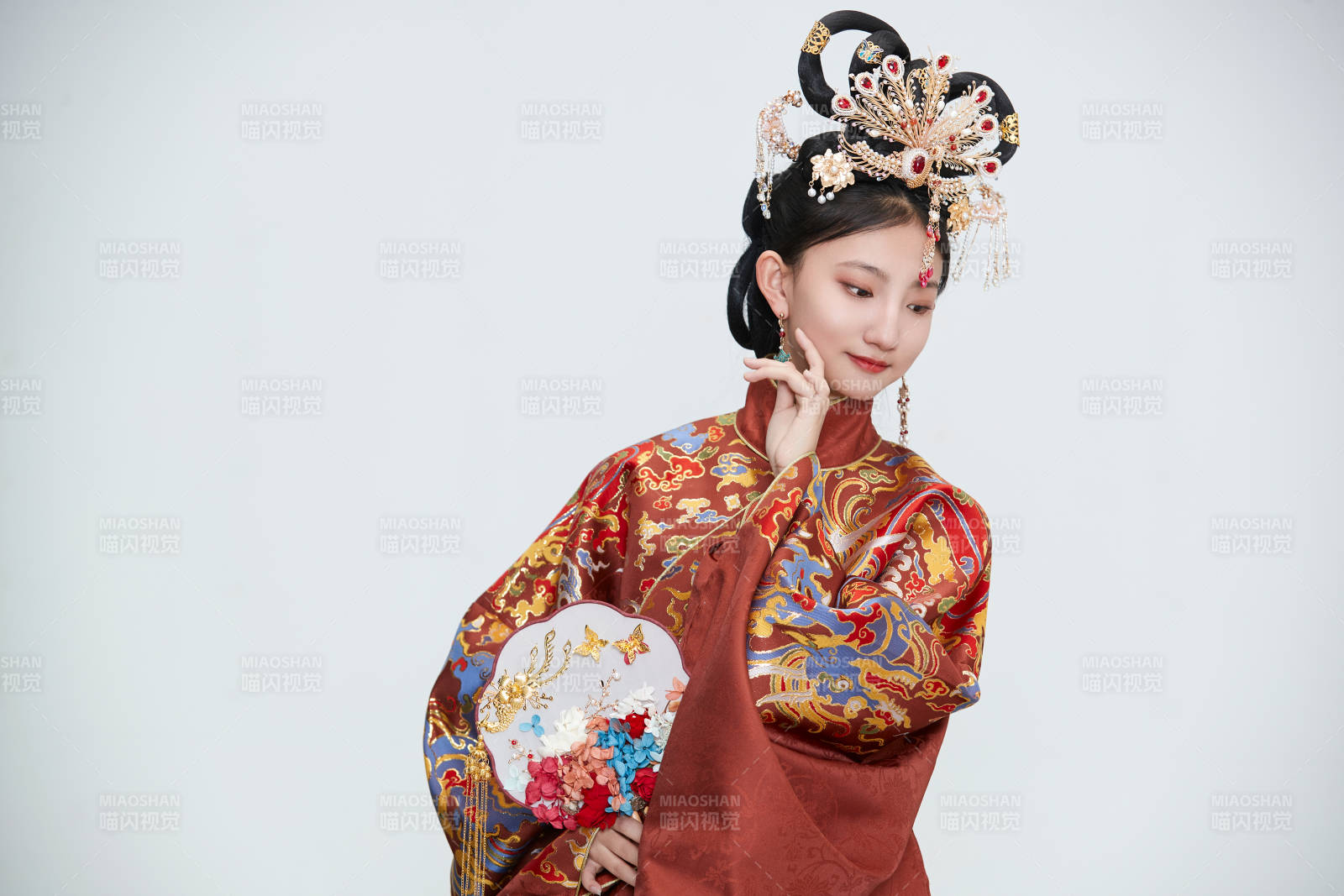 白色背景下穿著明代鳳冠霞帔漢服的可愛少女