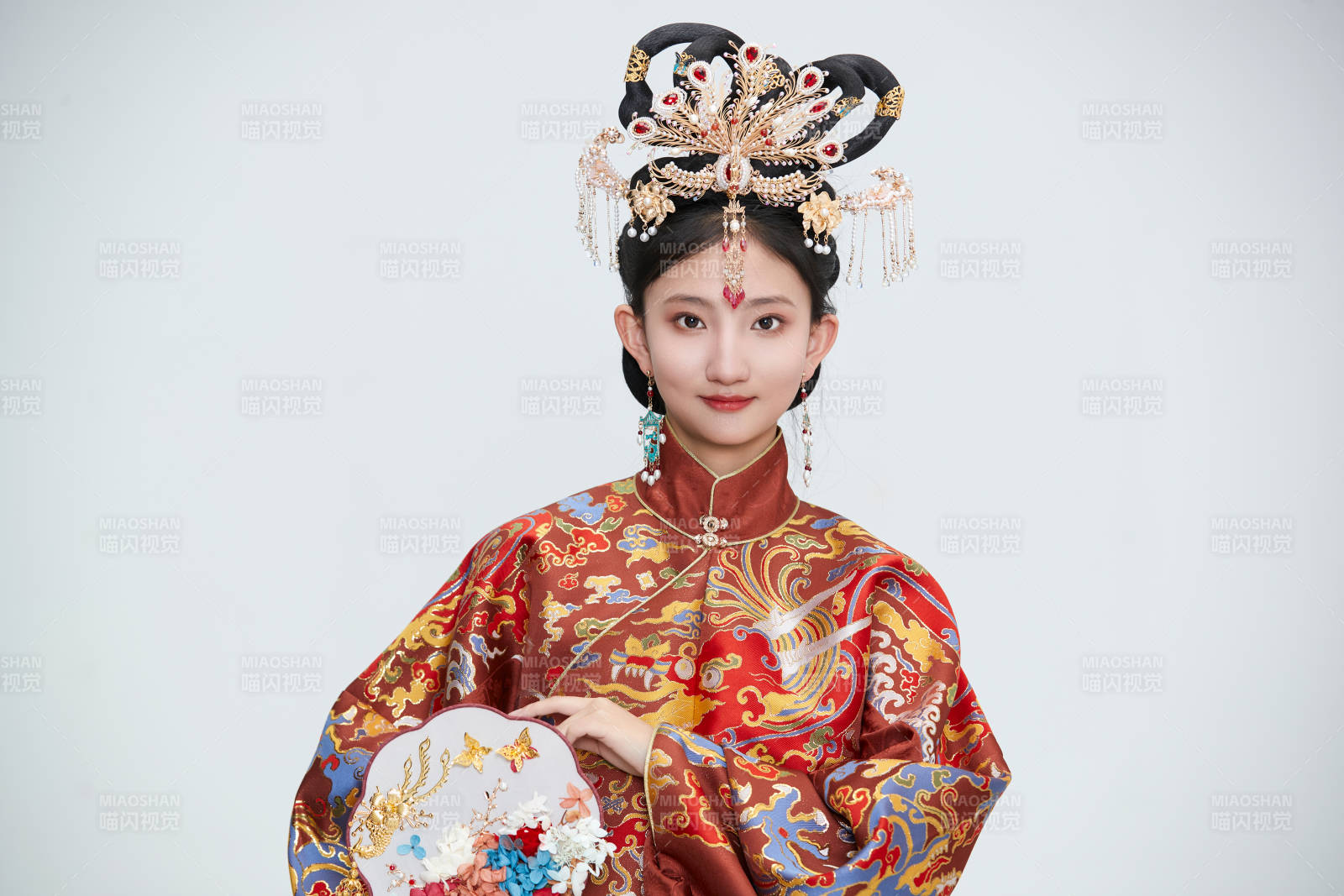 白色背景下穿著明代鳳冠霞帔漢服的可愛少女
