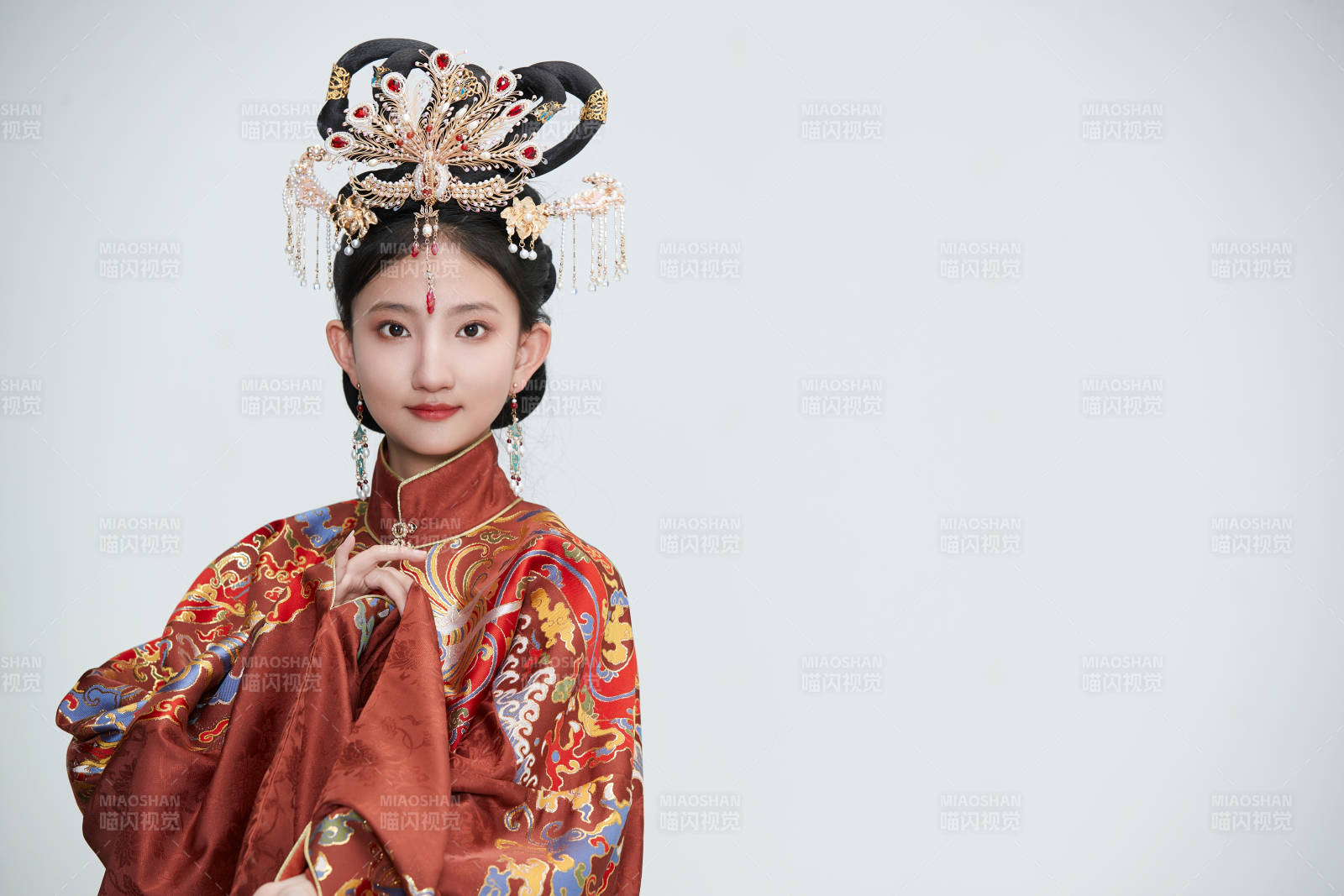 白色背景下穿著明代鳳冠霞帔漢服的可愛(ài)少女