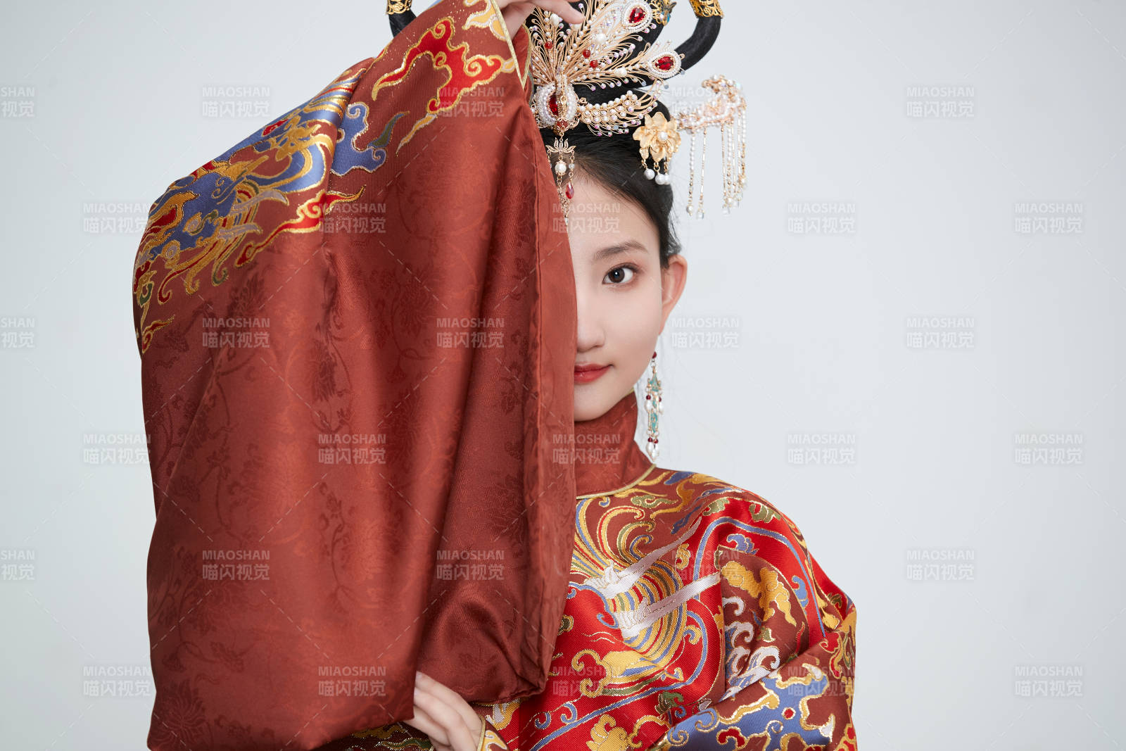 白色背景下穿著明代鳳冠霞帔漢服的可愛少女