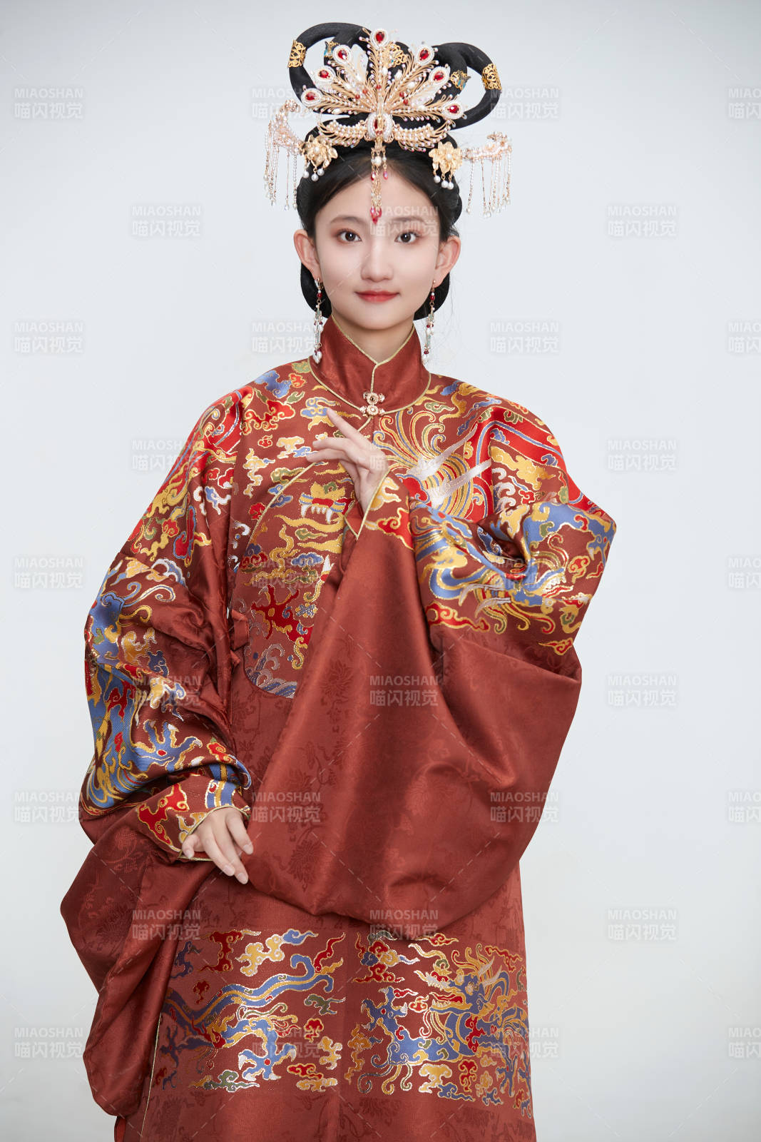白色背景下穿著明代鳳冠霞帔漢服的可愛少女