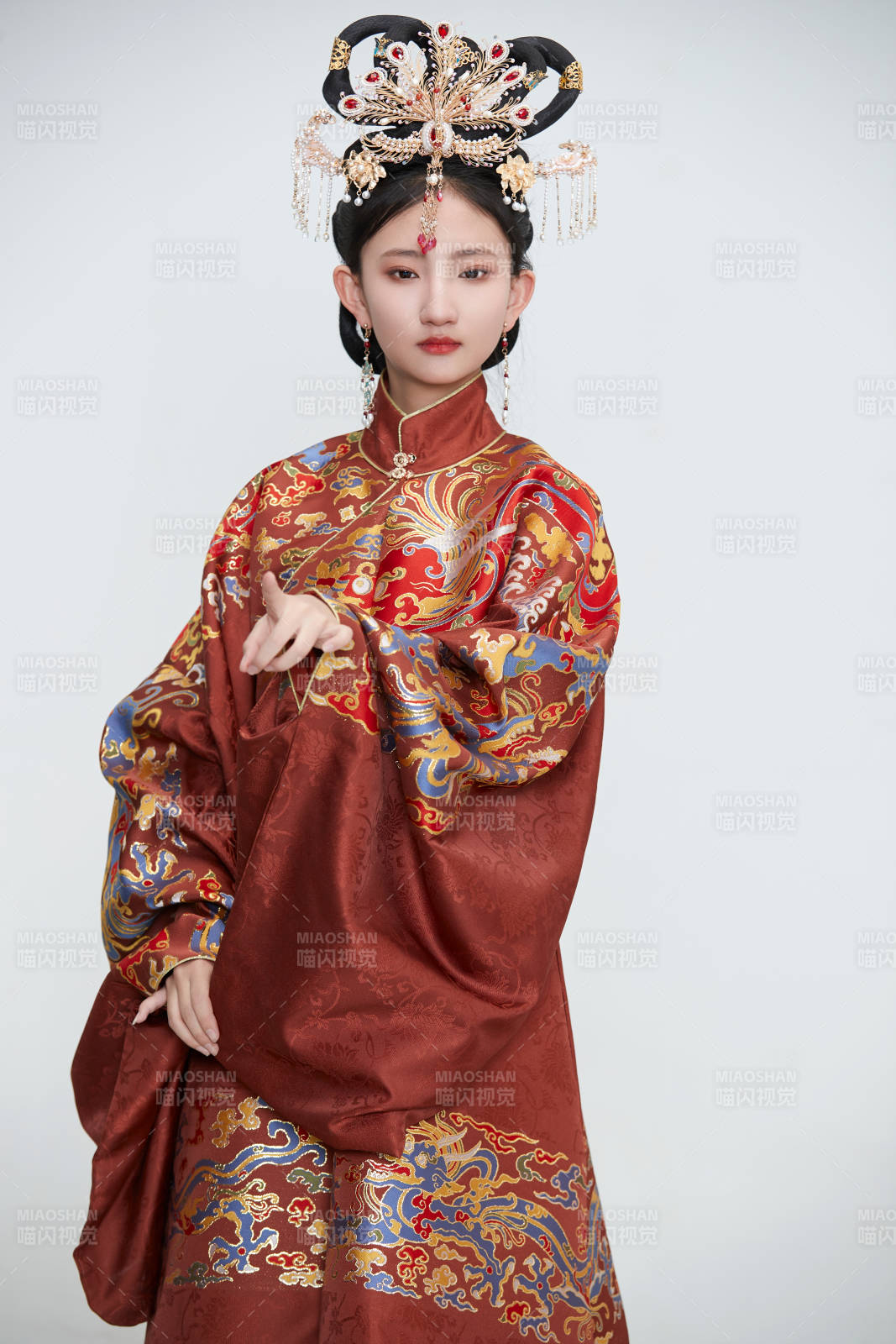 白色背景下穿著明代鳳冠霞帔漢服的可愛(ài)少女