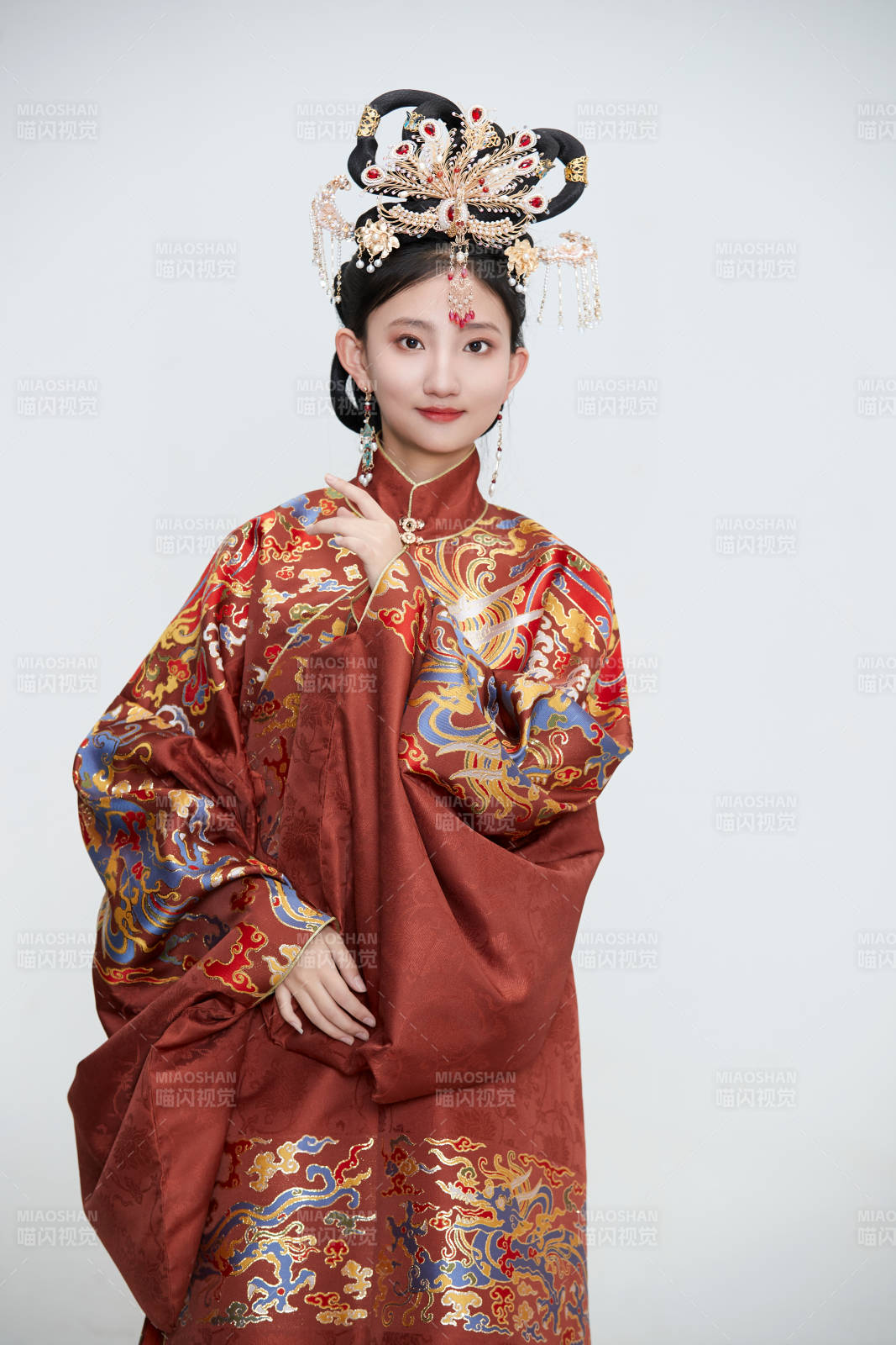 白色背景下穿著明代鳳冠霞帔漢服的可愛少女