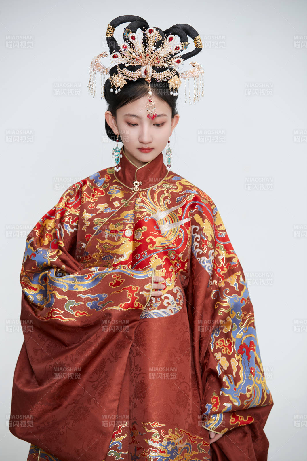 白色背景下穿著明代鳳冠霞帔漢服的可愛少女