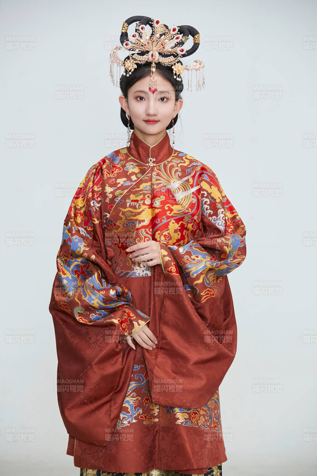 白色背景下穿著明代鳳冠霞帔漢服的可愛少女