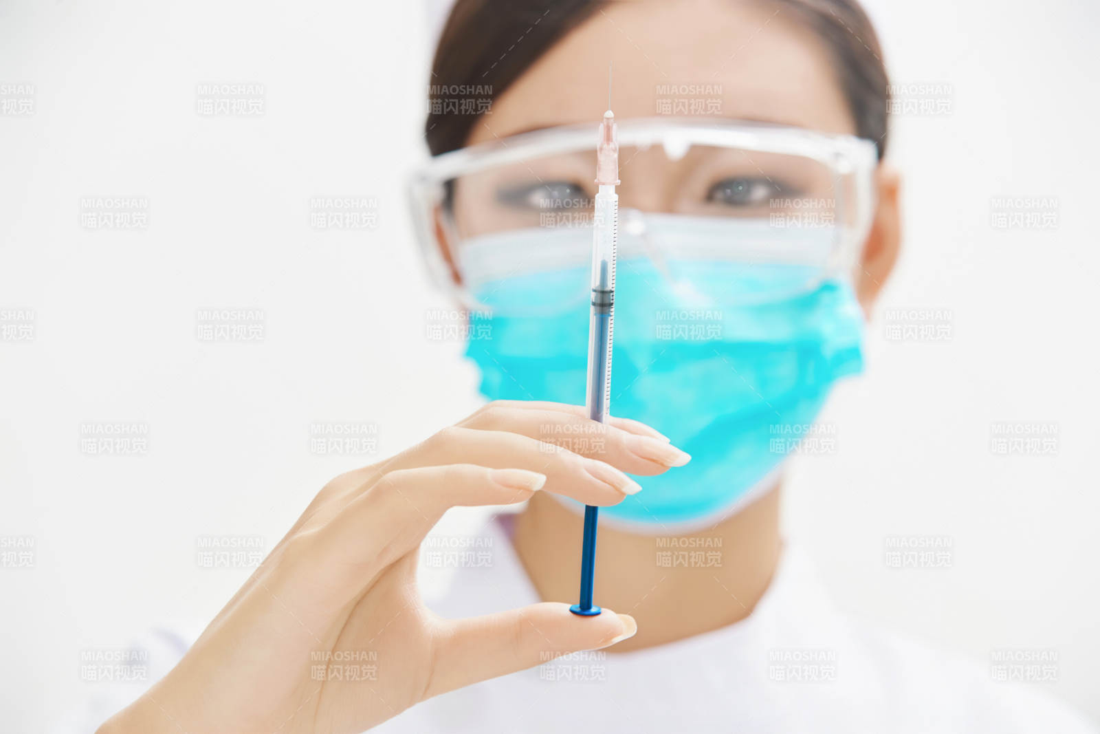 穿護士服戴口罩手執針筒的年輕女護士