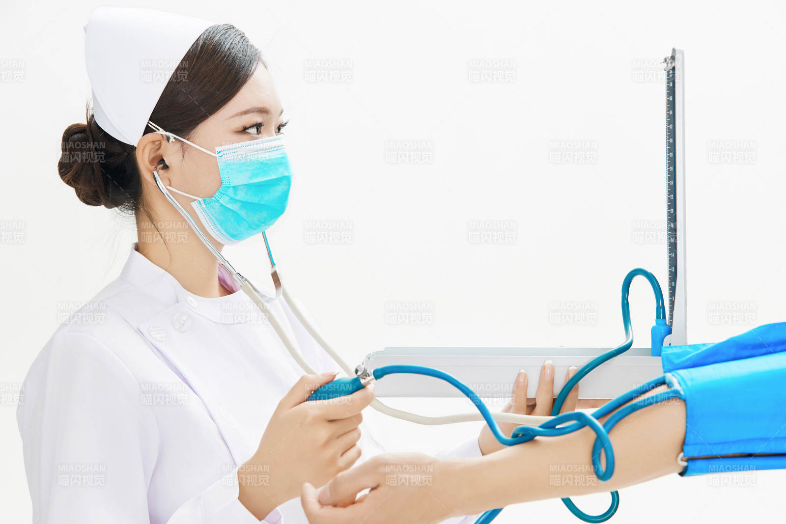 白色背景下手持血壓計為患者測量血壓的護士