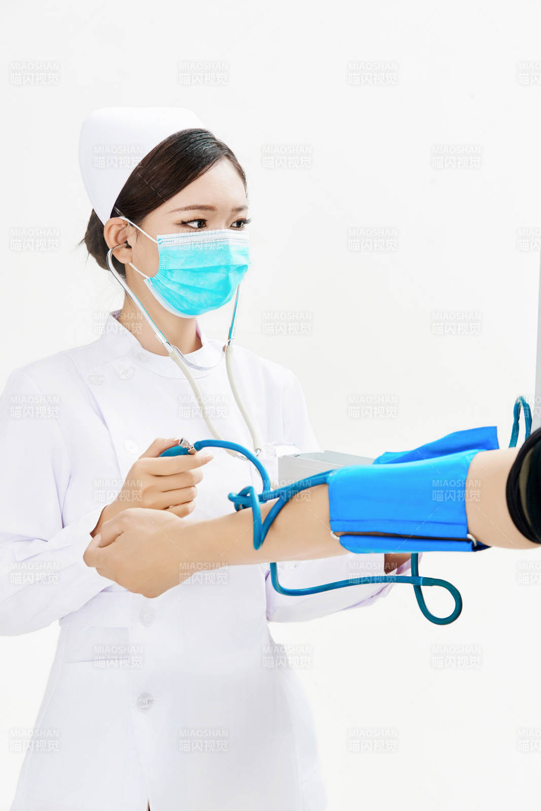 白色背景下手持血壓計為患者測量血壓的護士