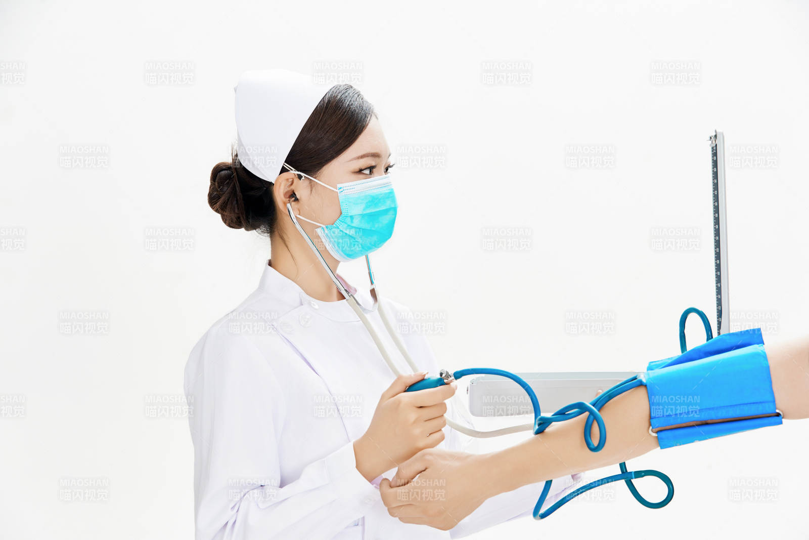 白色背景下手持血壓計(jì)為患者測(cè)量血壓的護(hù)士