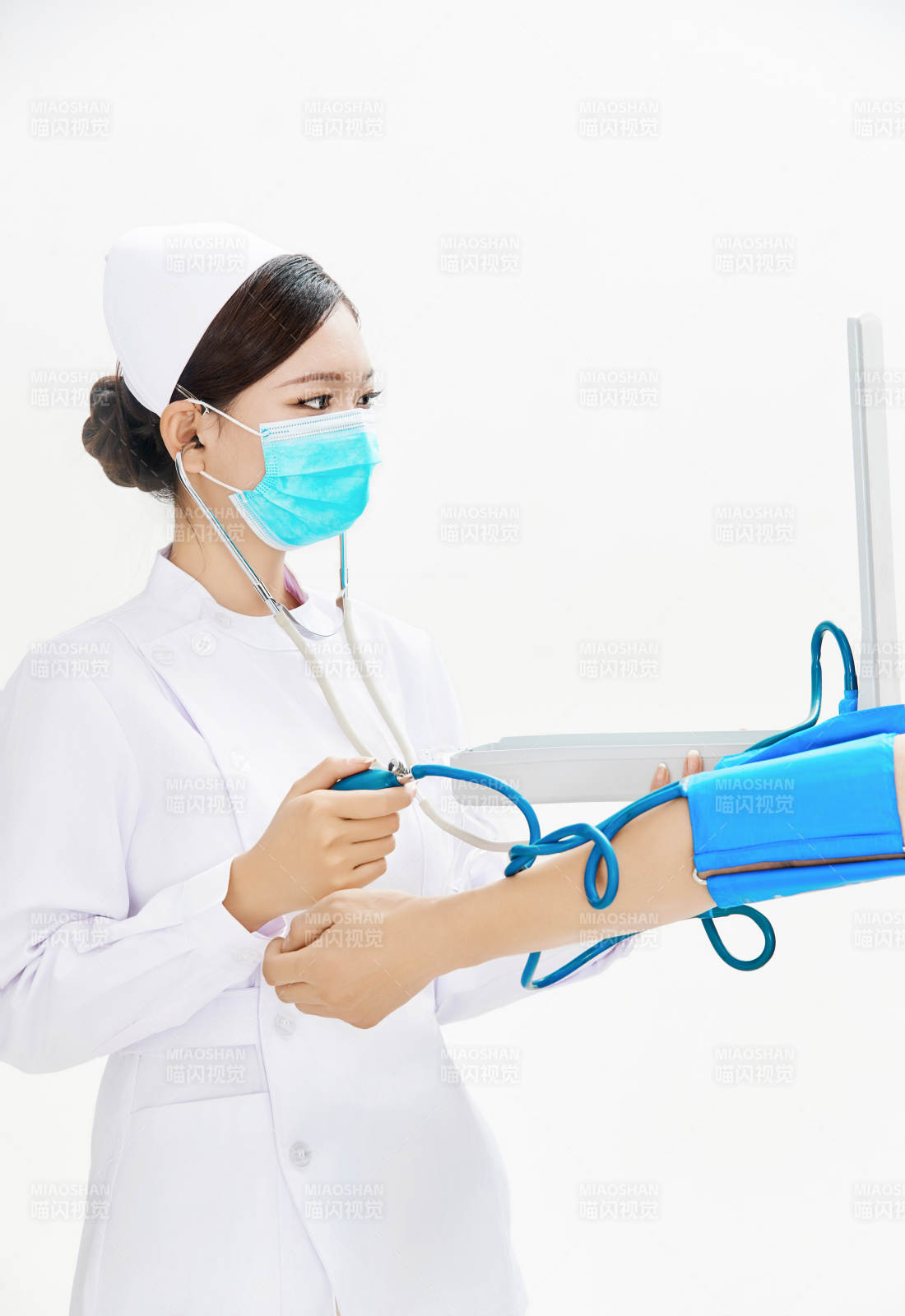 白色背景下手持血壓計為患者測量血壓的護士