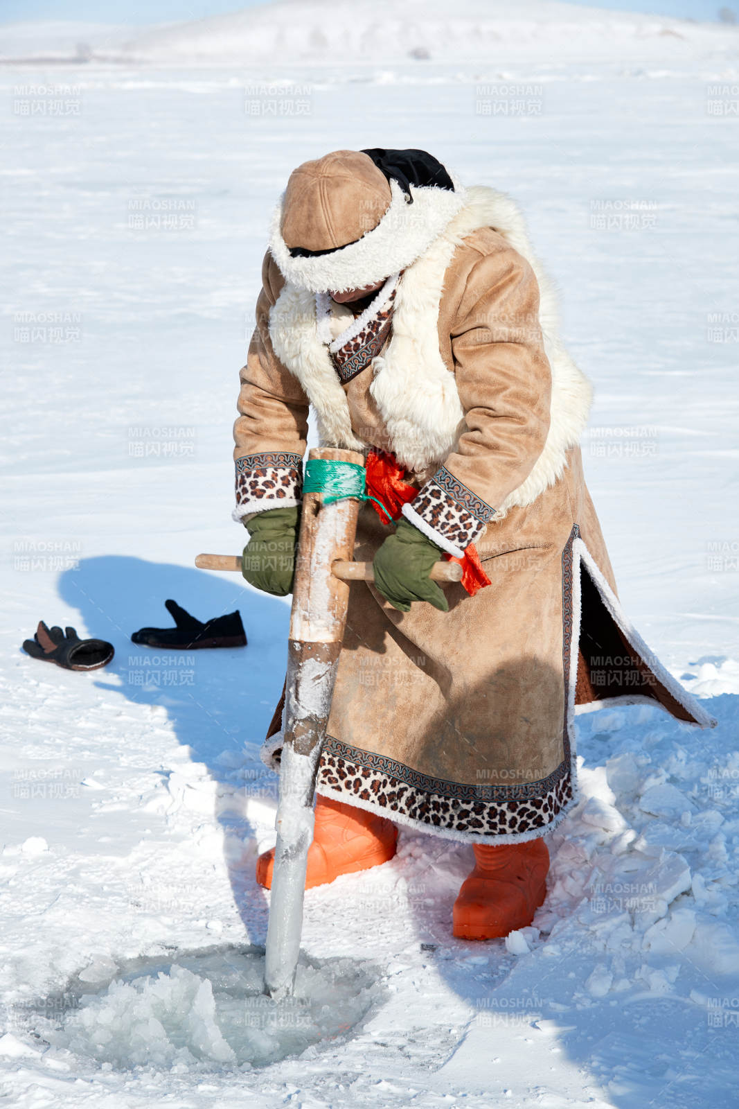 寒冷的冬季在冰凍的湖面上鑿冰捕魚的人們