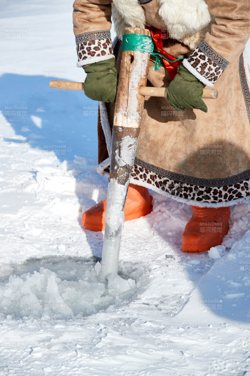 寒冷的冬季在冰凍的湖面上鑿冰捕魚的人們