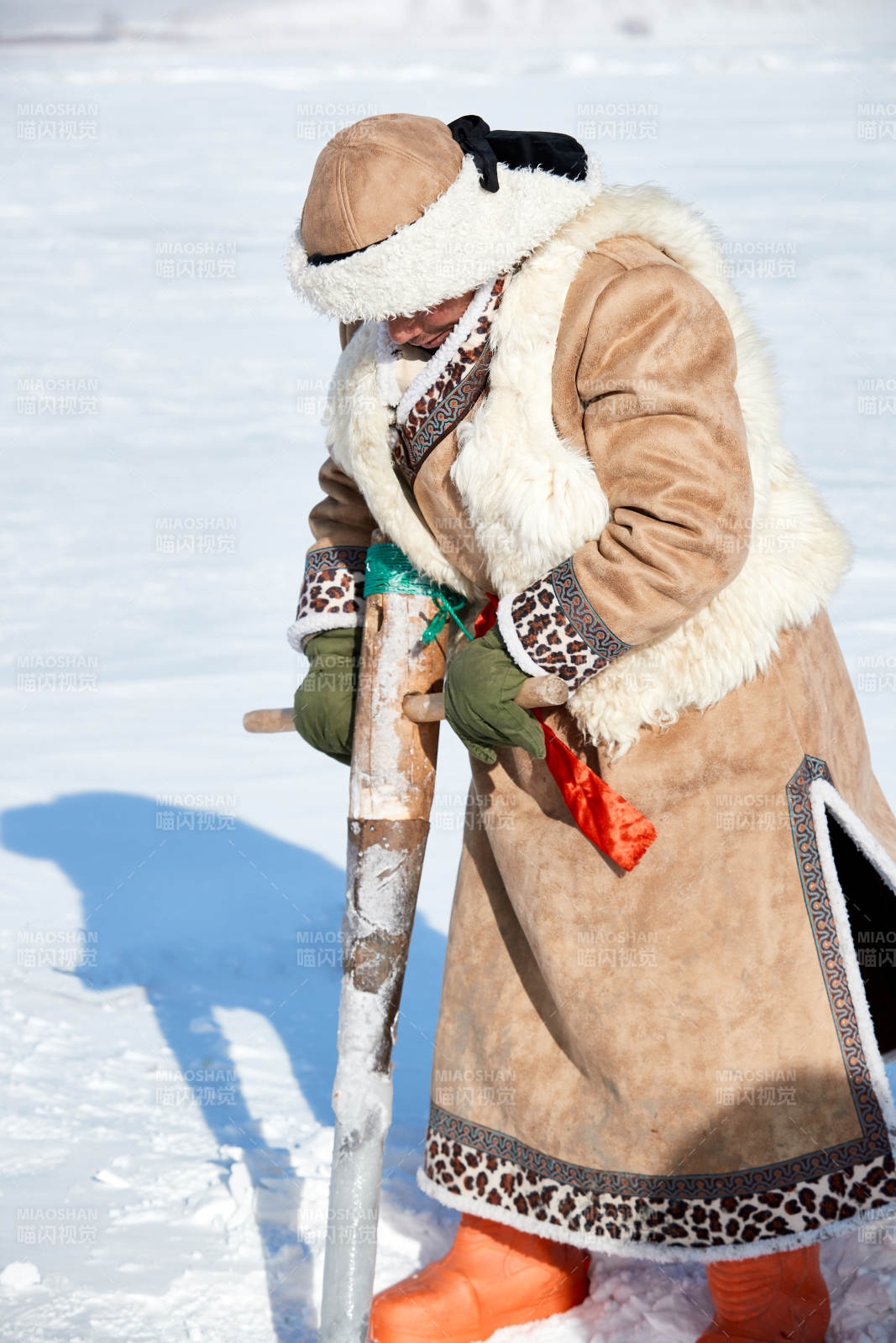 寒冷的冬季在冰凍的湖面上鑿冰捕魚的人們