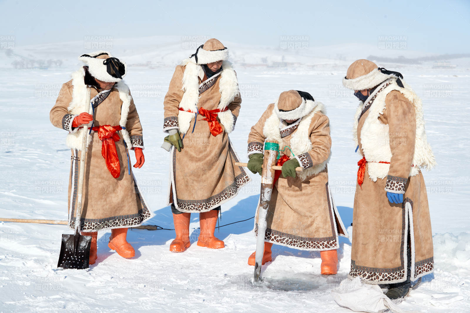 寒冷的冬季在冰凍的湖面上鑿冰捕魚的人們