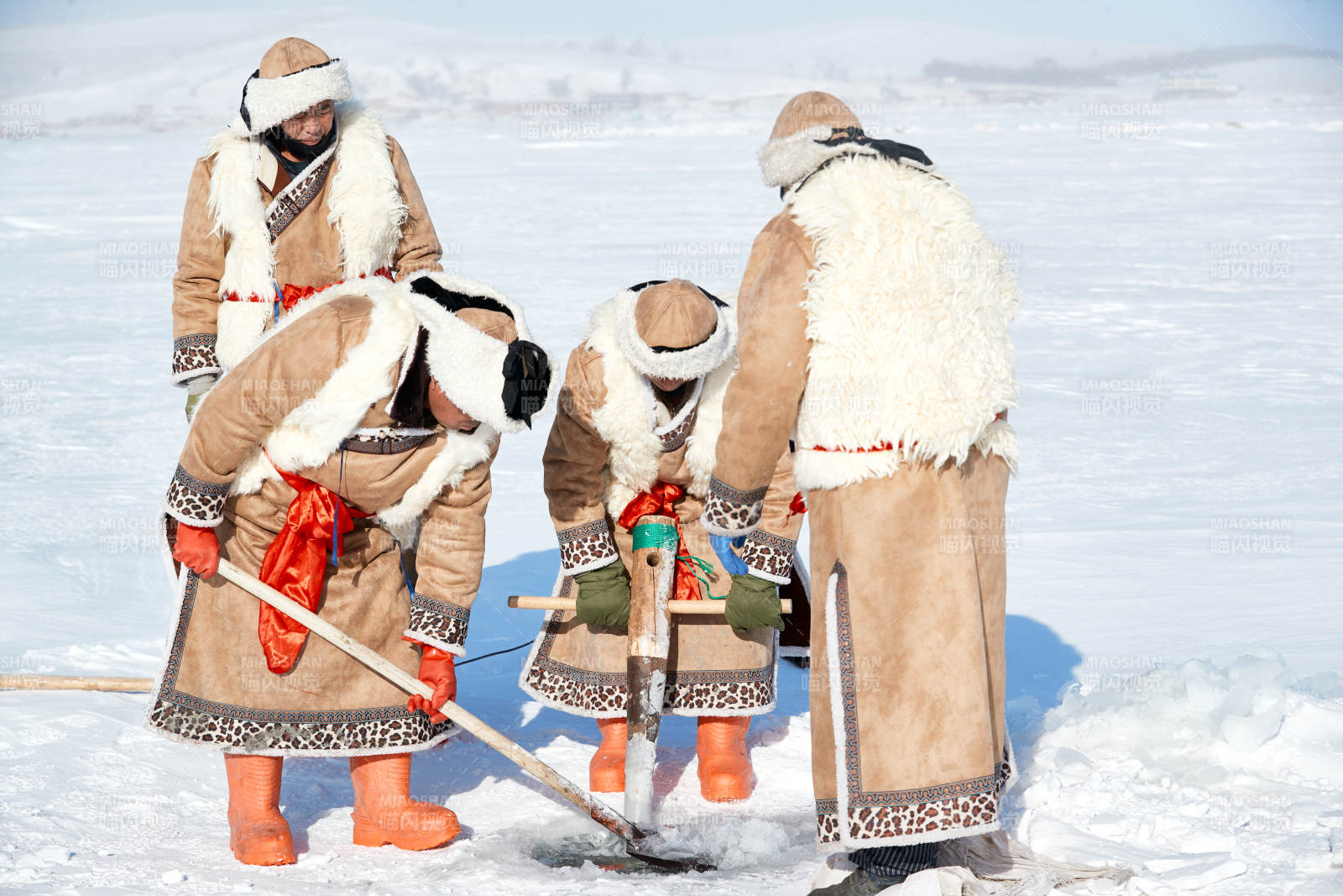 寒冷的冬季在冰凍的湖面上鑿冰捕魚的人們