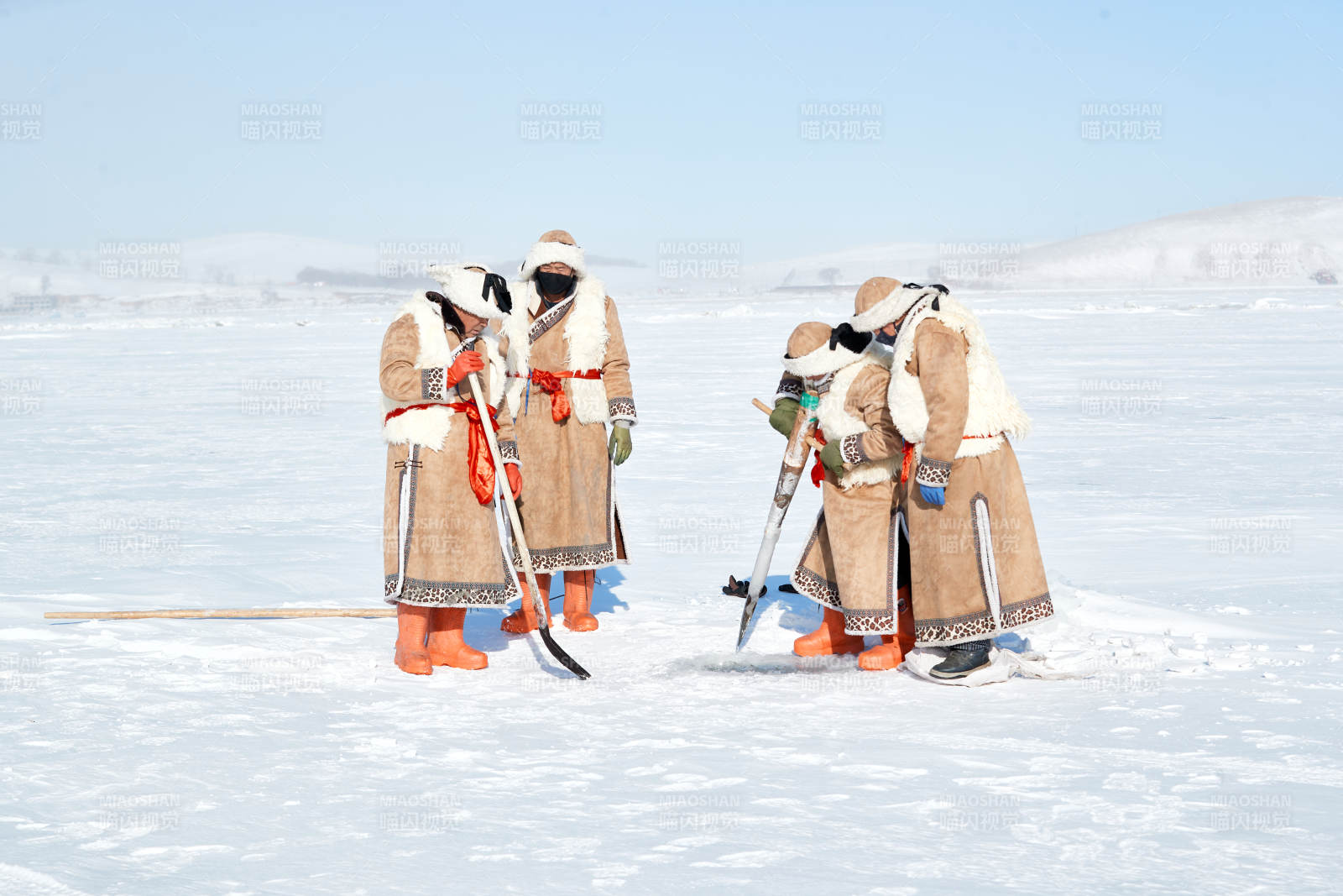 寒冷的冬季在冰凍的湖面上鑿冰捕魚的人們