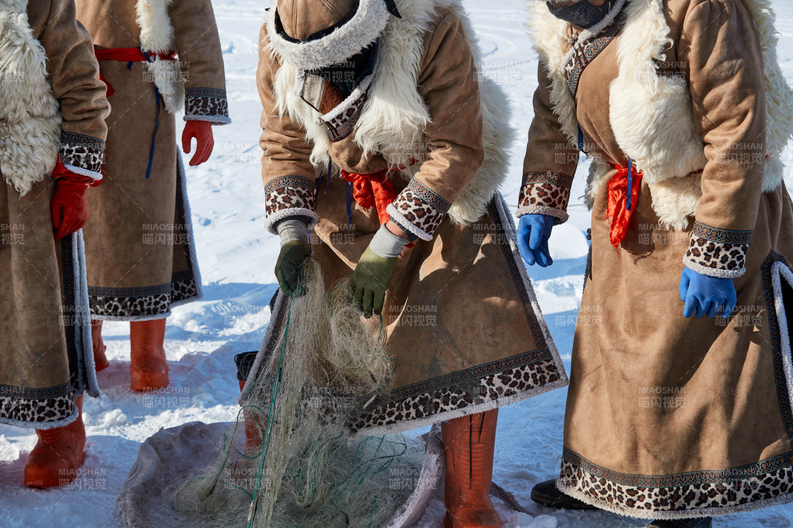寒冷的冬季在冰凍的湖面上鑿冰捕魚的人們