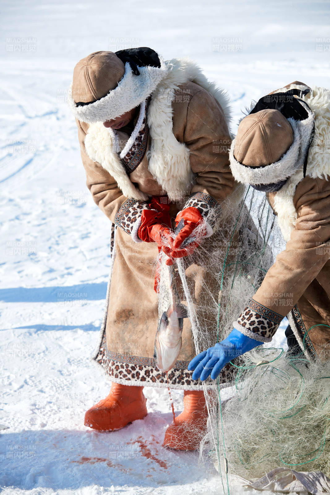 寒冷的冬季在冰凍的湖面上鑿冰捕魚的人們