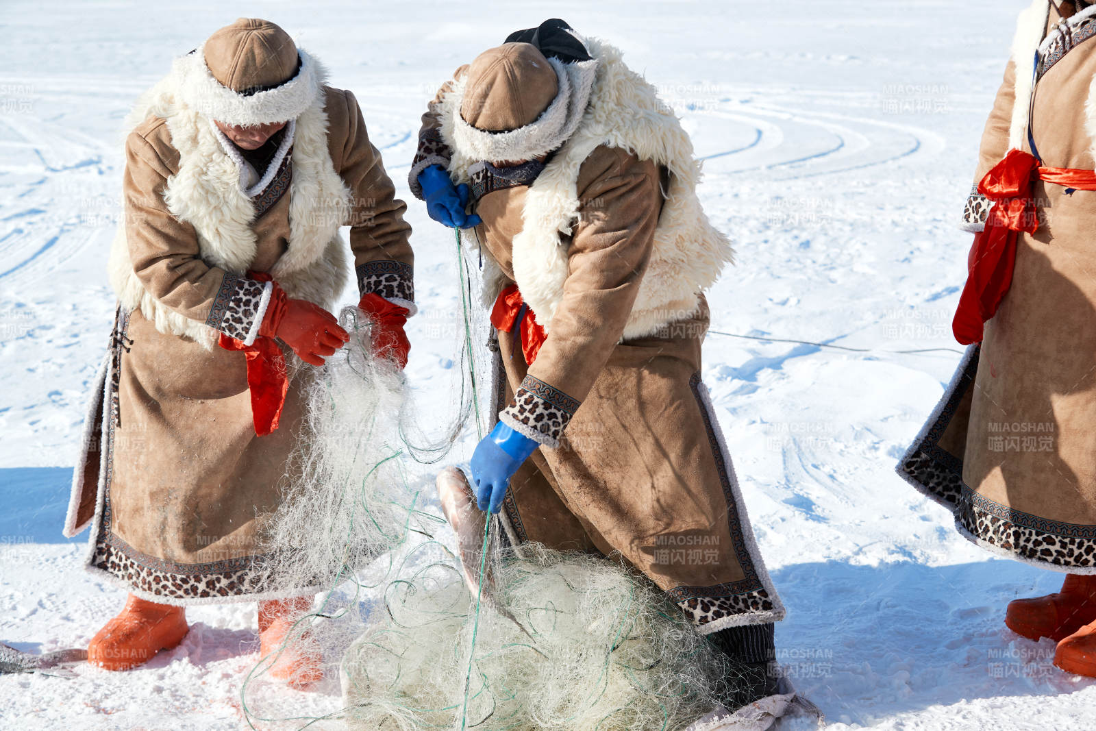 寒冷的冬季在冰凍的湖面上鑿冰捕魚的人們