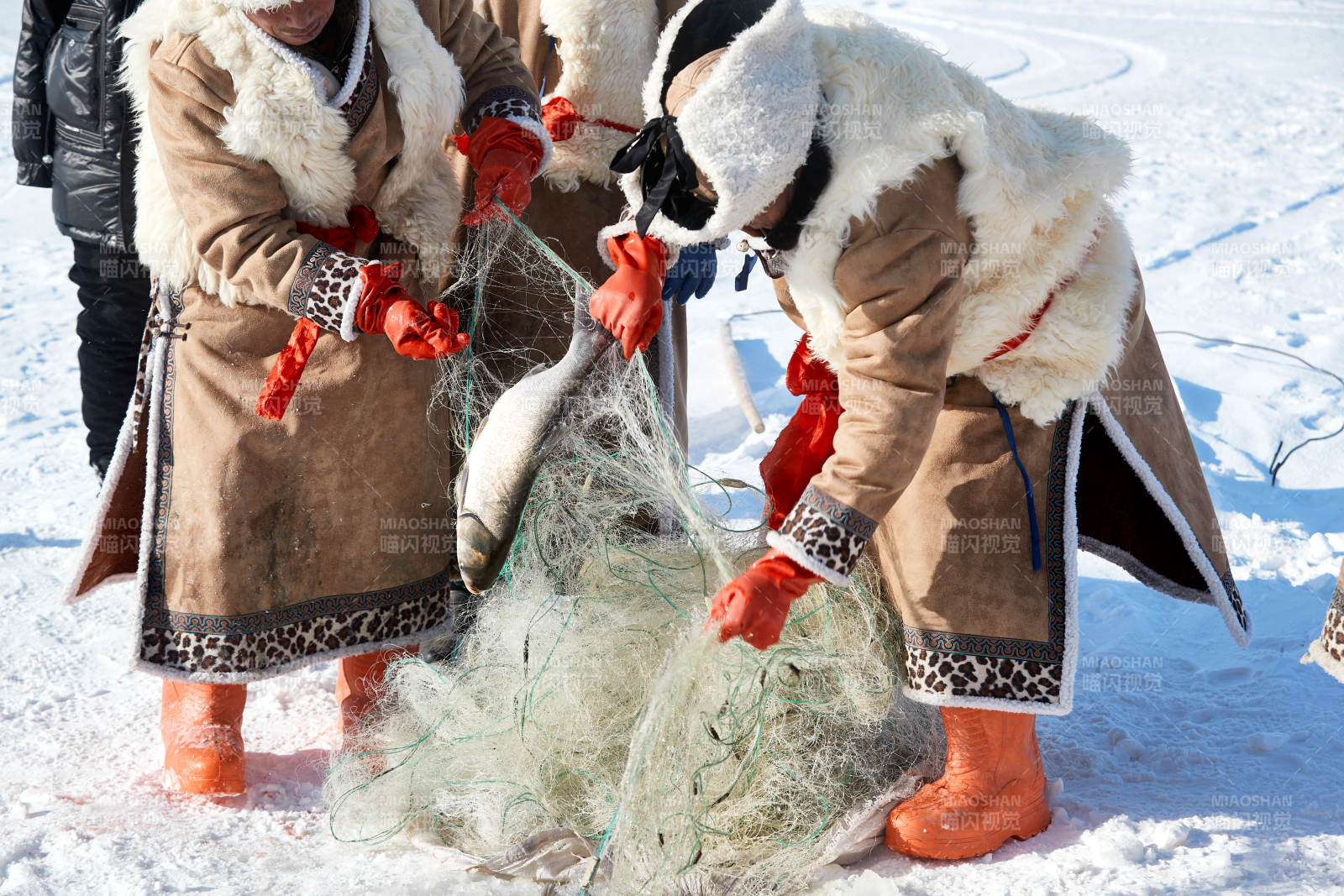 寒冷的冬季在冰凍的湖面上鑿冰捕魚的人們