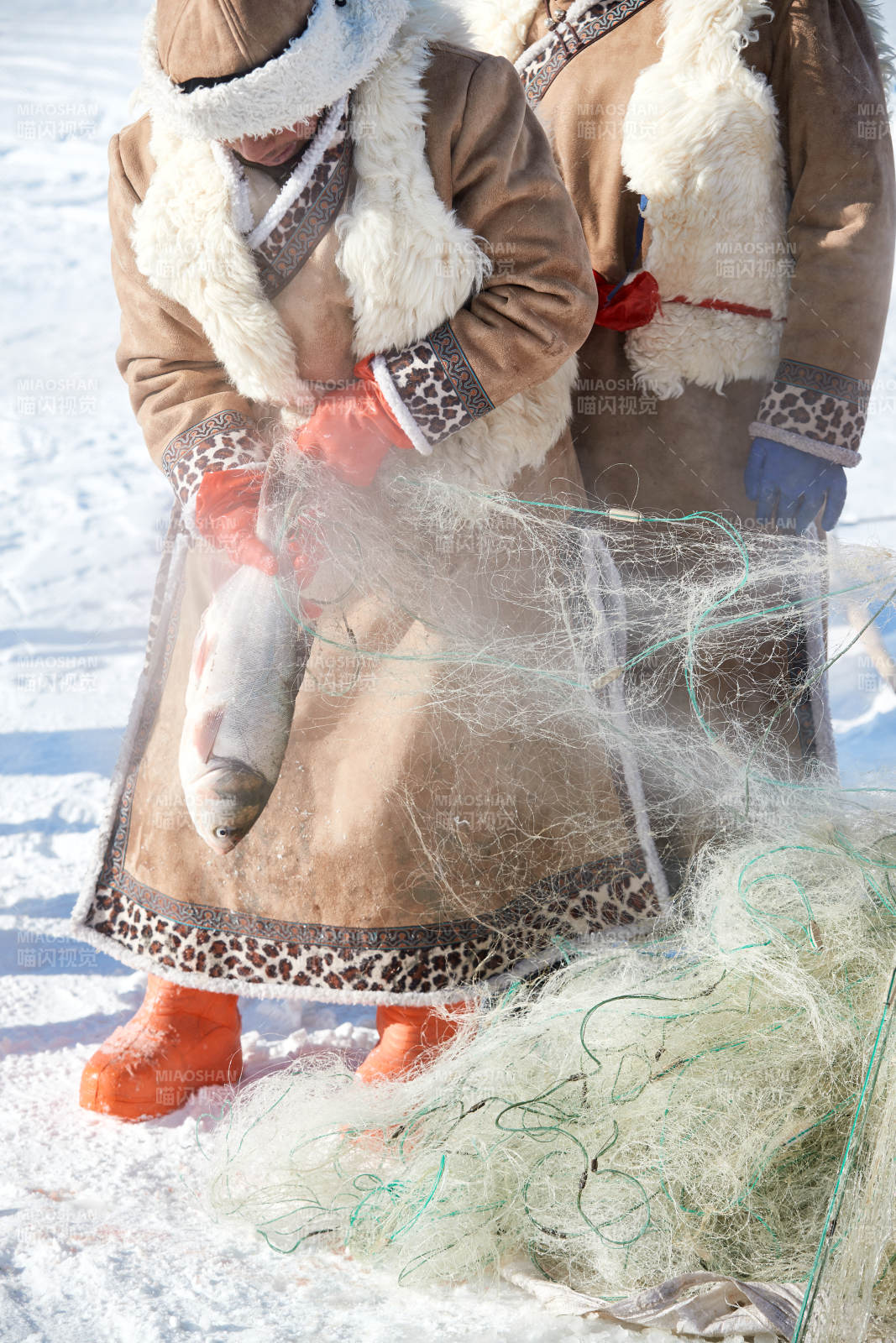 寒冷的冬季在冰凍的湖面上鑿冰捕魚的人們