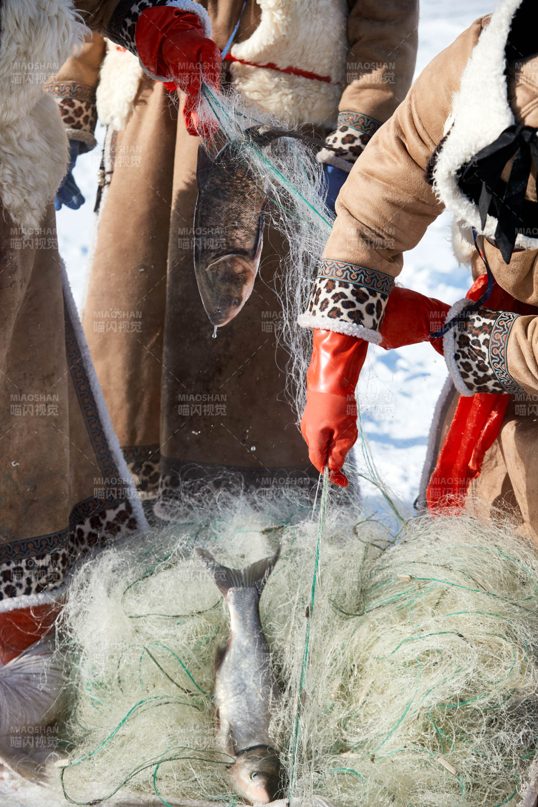 寒冷的冬季在冰凍的湖面上鑿冰捕魚的人們