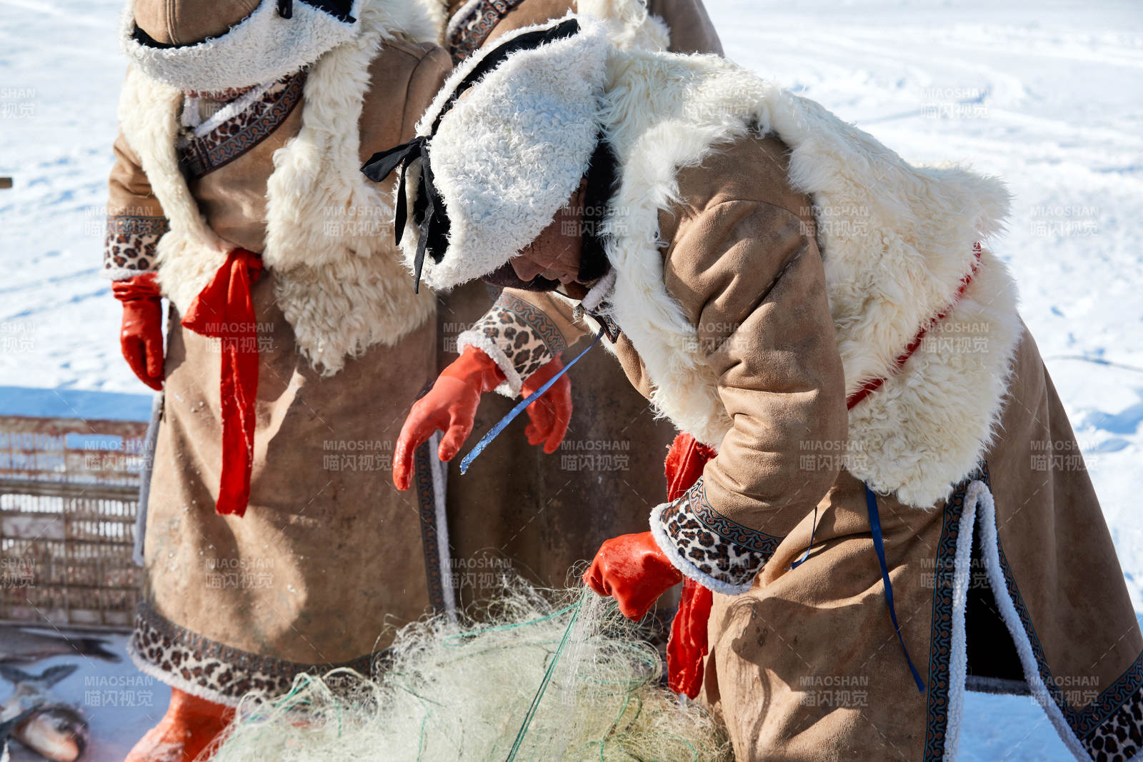 寒冷的冬季在冰凍的湖面上鑿冰捕魚的人們