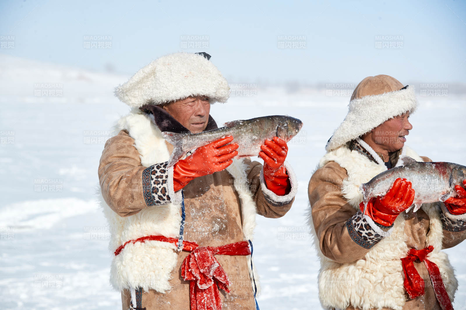 寒冷的冬季在冰凍的湖面上鑿冰捕魚的人們