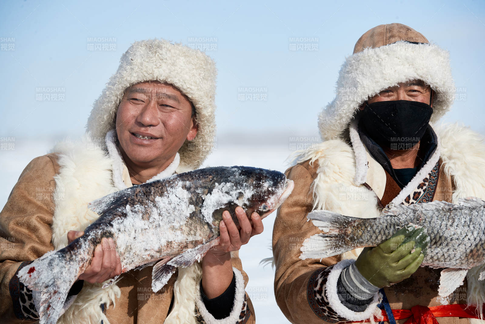 寒冷的冬季在冰凍的湖面上鑿冰捕魚的人們