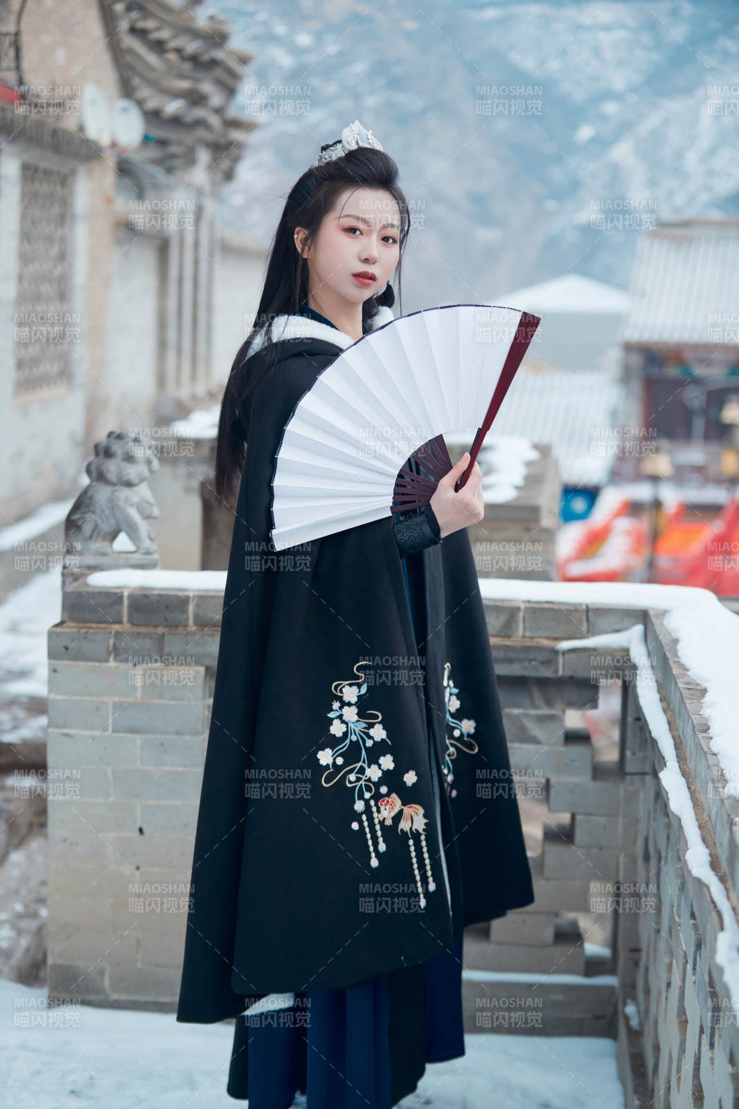 雪天古城身穿漢服扮演武俠的中國少女