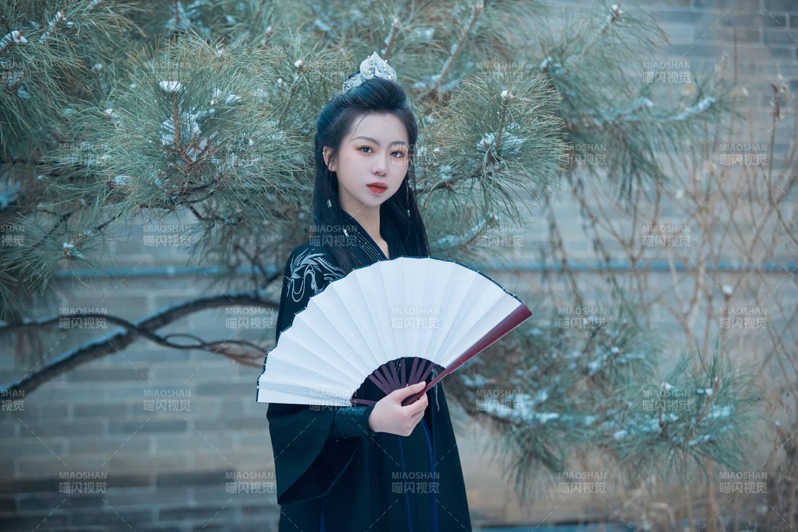 雪天古城身穿漢服扮演武俠的中國少女