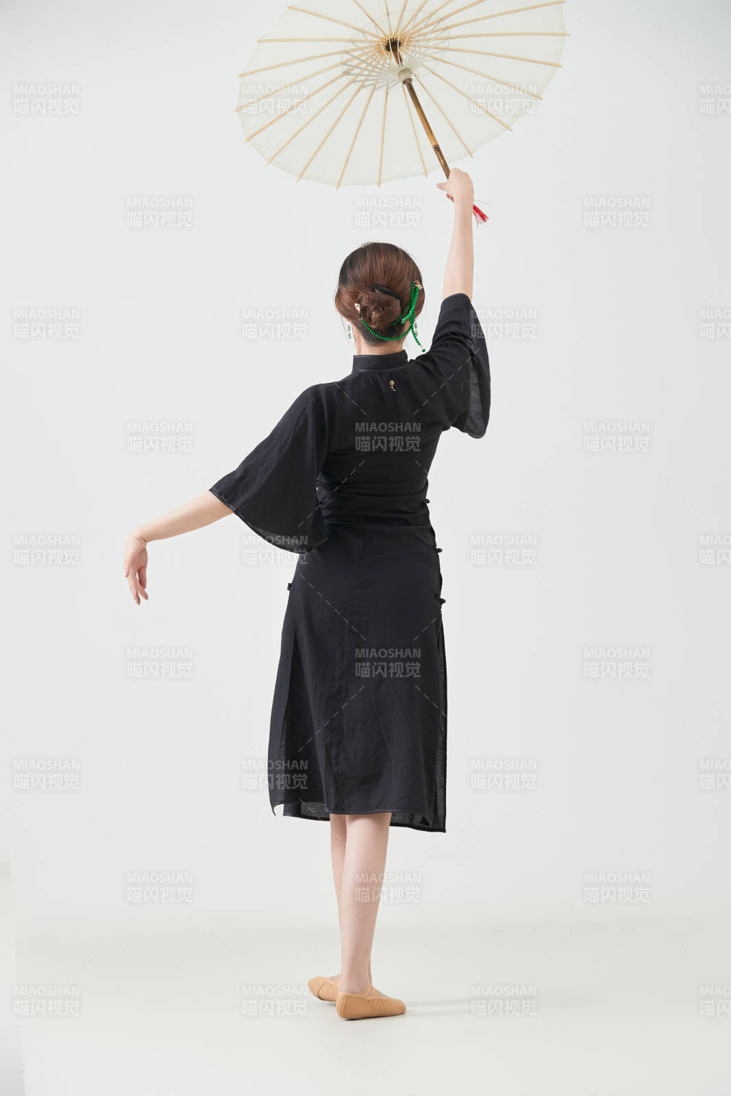 穿中式旗袍手拿油紙傘翩翩舞蹈的亞洲少女舞者