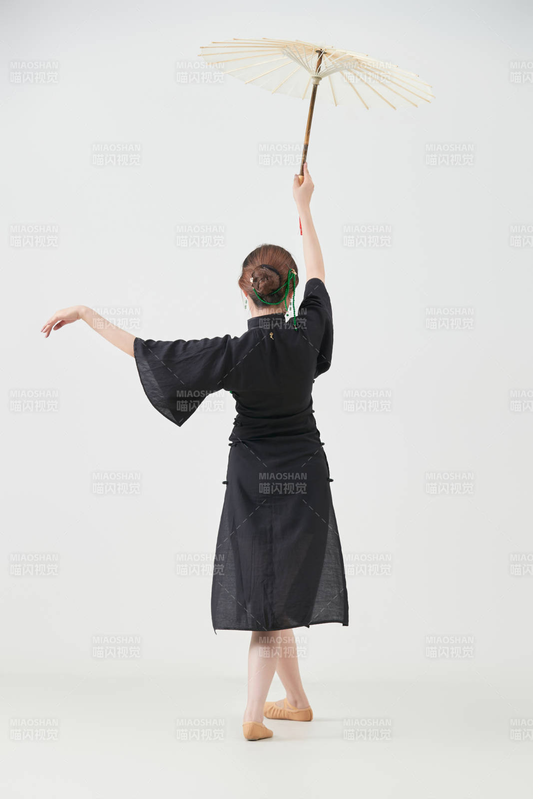 穿中式旗袍手拿油紙傘翩翩舞蹈的亞洲少女舞者