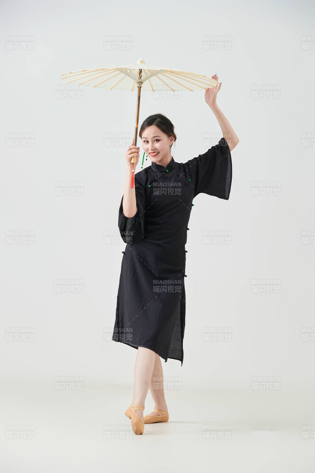 穿中式旗袍手拿油紙傘翩翩舞蹈的亞洲少女舞者