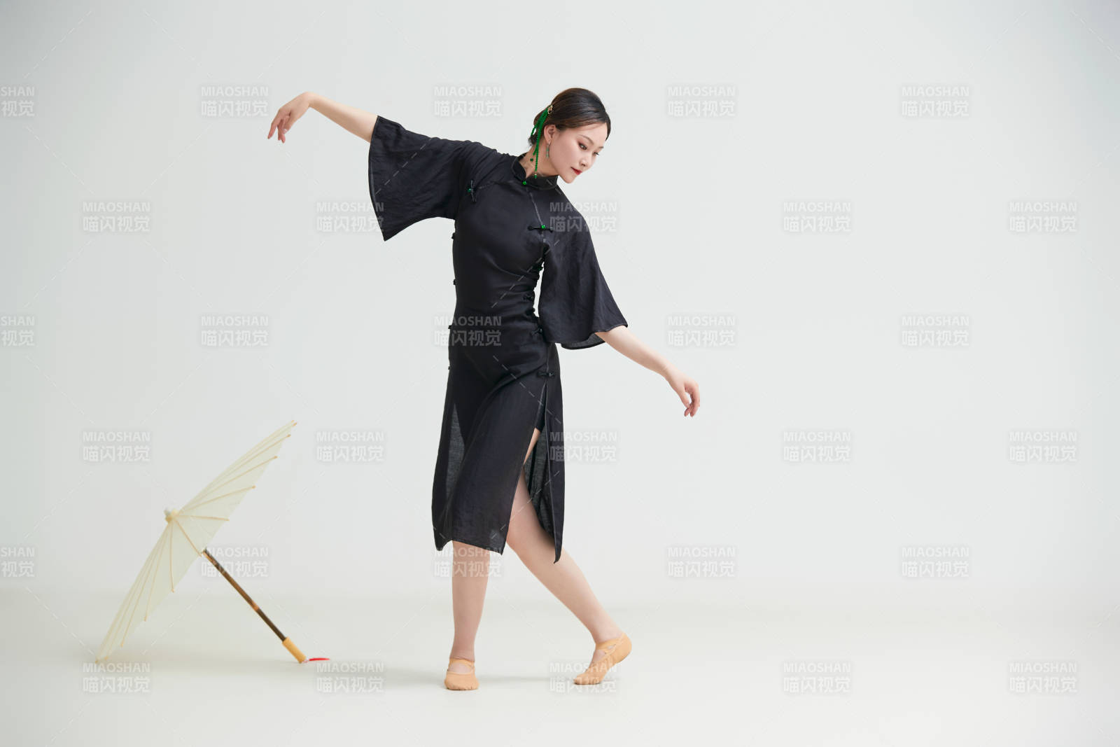 穿中式旗袍手拿油紙傘翩翩舞蹈的亞洲少女舞者