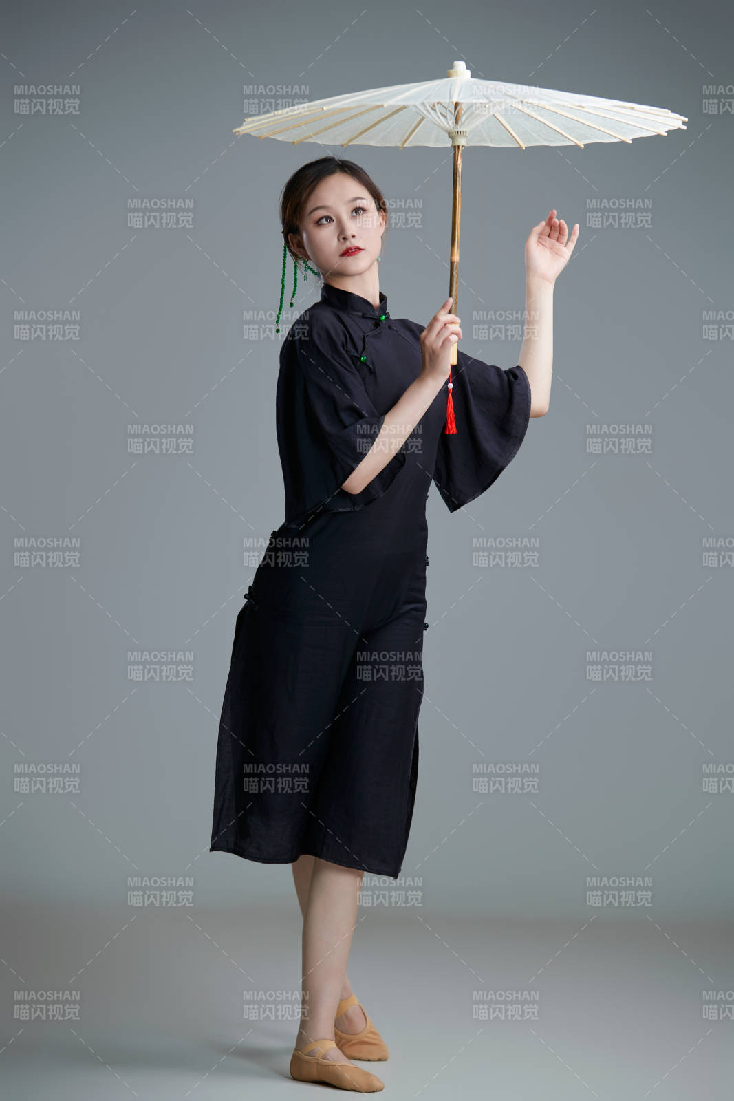 穿中式旗袍手拿油紙傘翩翩舞蹈的亞洲少女舞者