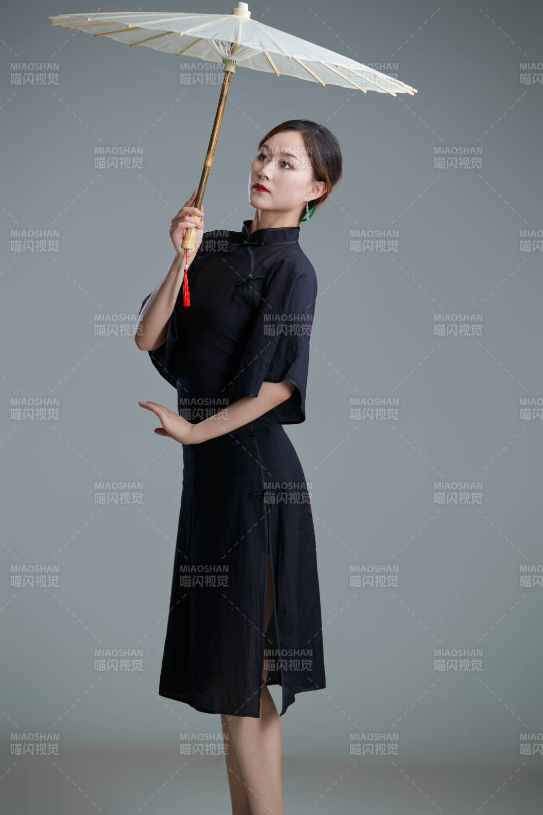 穿中式旗袍手拿油紙傘翩翩舞蹈的亞洲少女舞者